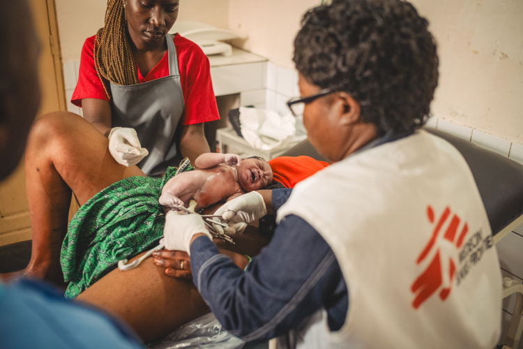 Daddy Ngeve, sage-femme et responsable des activités santé maternelle au centre de santé de Kanyaruchinya soutenu par MSF, au nord de Goma, Nord-Kivu, République démocratique du Congo, coupe le cordon ombilical après avoir aidé à accoucher Gisele Dorika, 18 ans, le 5 janvier 2024. Dans cette maternité, environ 3 300 femmes ont accouché en 2023, soit une moyenne de 10 accouchements par jour. Copyright : Philémon Barbier Daddy Ngeve, sage-femme et responsable des activités santé maternelle au centre de santé de Kanyaruchinya soutenu par MSF, au nord de Goma, Nord-Kivu, République démocratique du Congo, coupe le cordon ombilical après avoir aidé à accoucher Gisele Dorika, 18 ans, le 5 janvier 2024. Dans cette maternité, environ 3 300 femmes ont accouché en 2023, soit une moyenne de 10 accouchements par jour. Copyright : Philémon Barbier