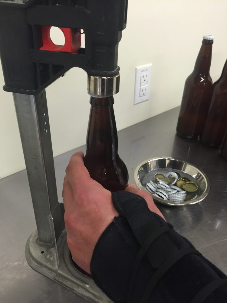 Bottles filled with Worth the Wait Cantaloupe Gose are capped.