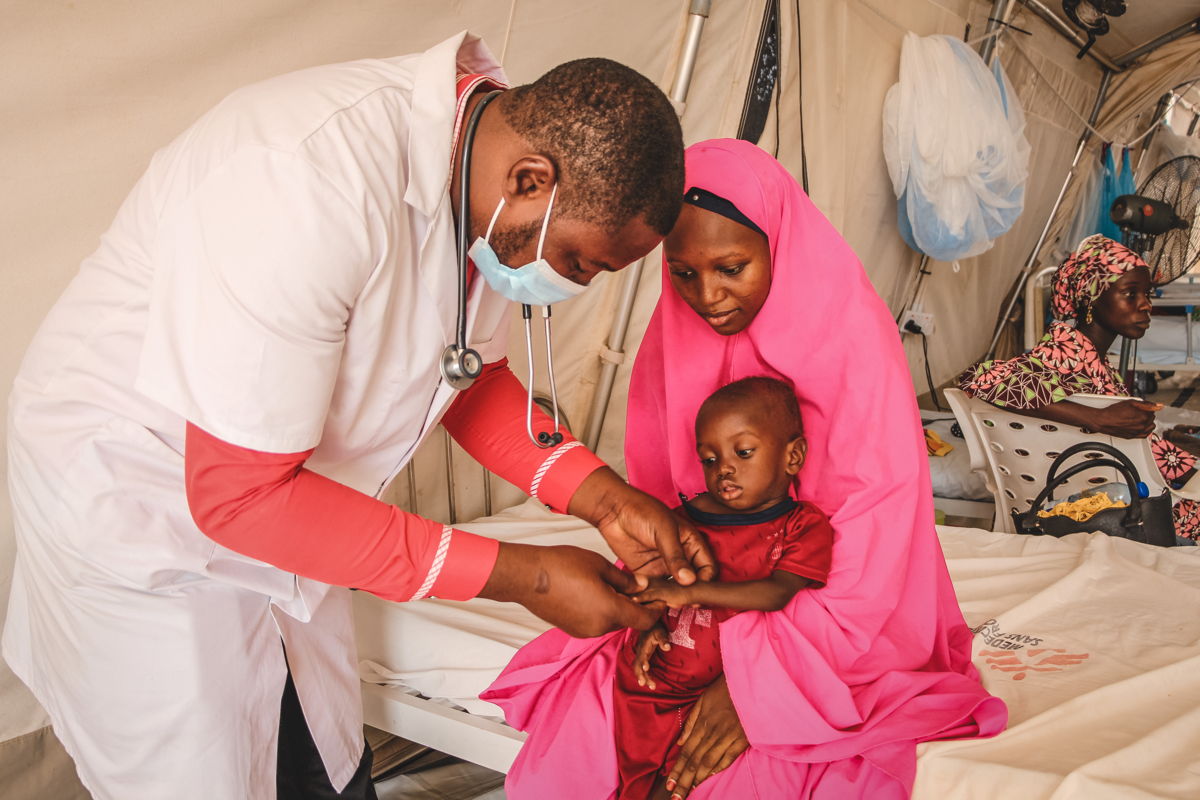 Artsen zonder Grenzen Ibrahim Fori Bwala onderzoekt een ernstig ondervoed kind dat is opgenomen in het intramurale therapeutische voedingscentrum (ITFC) in het voedingsziekenhuis Nilefa Kiji, gerund door AZG in Maiduguri, in de staat Borno in Nigeria.