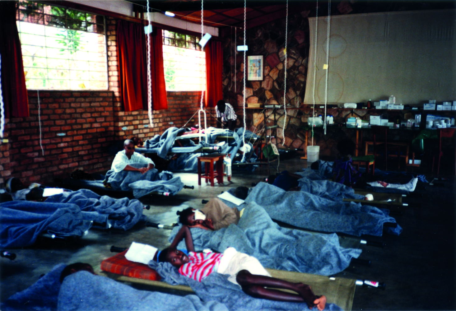 Kigali, genocide Rwandan Tutsis, april 1994. On 13 April 1994, an emergency surgical mission left together with ICRC from Bujumbura in Burundi to Kigali the Rwandan capital city where a few days before had started the genocide of the Rwandan Tutsis. Within hours, an orphanage was converted into a field hospital and the first patients arrived on the very evening of the team's arrival. From 13 April 1994 until Kigali was taken by the Rwandan Patriotic Front (RPF) early July 1994, MSF teams in collaboration with the ICRC ran this hospital that over the weeks became a real refuge for the survivors of the massacres. Photographer: Xavier Lassalle