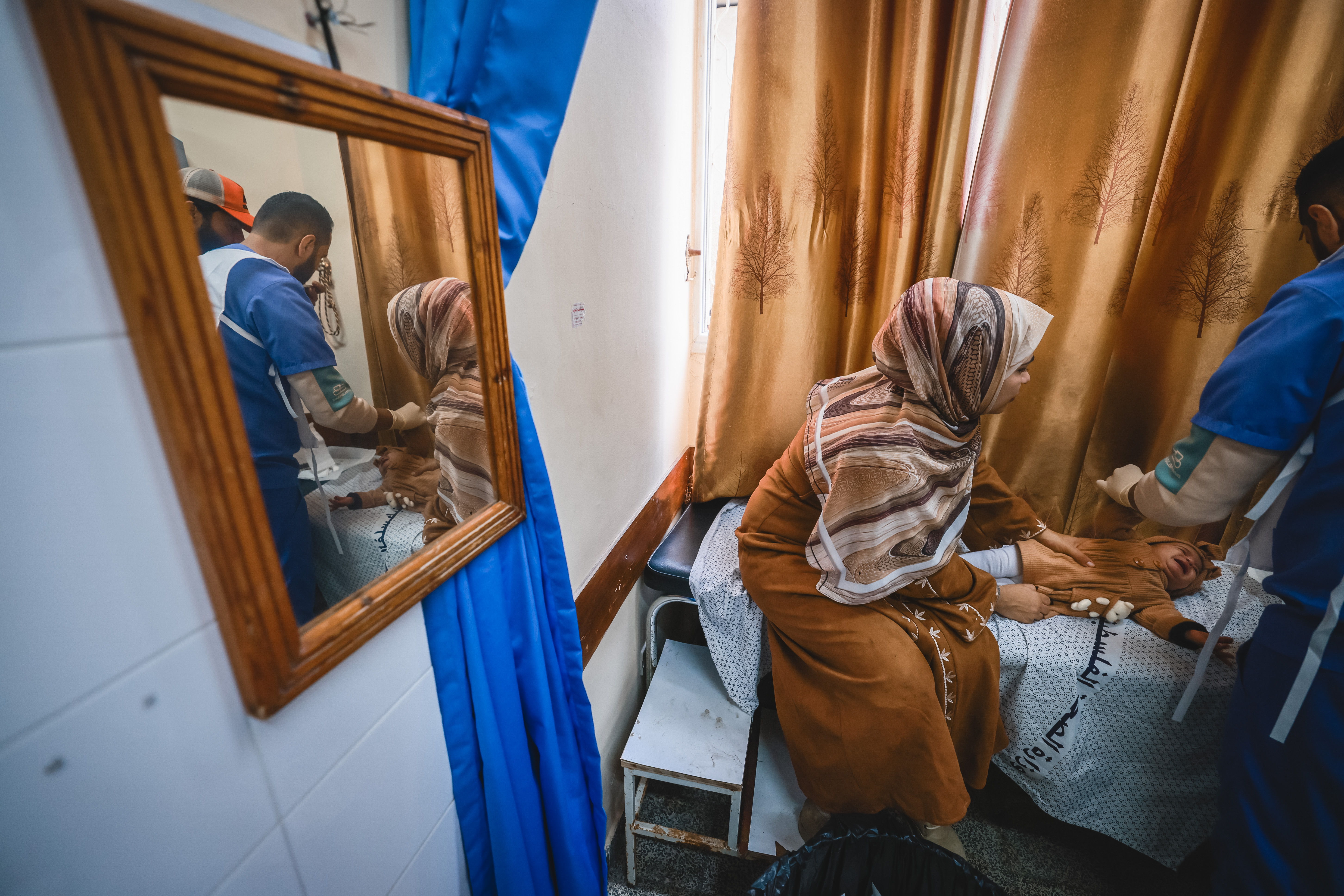 Un miembro de MSF atiende a una bebé en el Hospital de los Mártires, al sur de Gaza. © Mohammed Abed. Un miembro de MSF atiende a una bebé en el Hospital de los Mártires, al sur de Gaza. © Mohammed Abed.