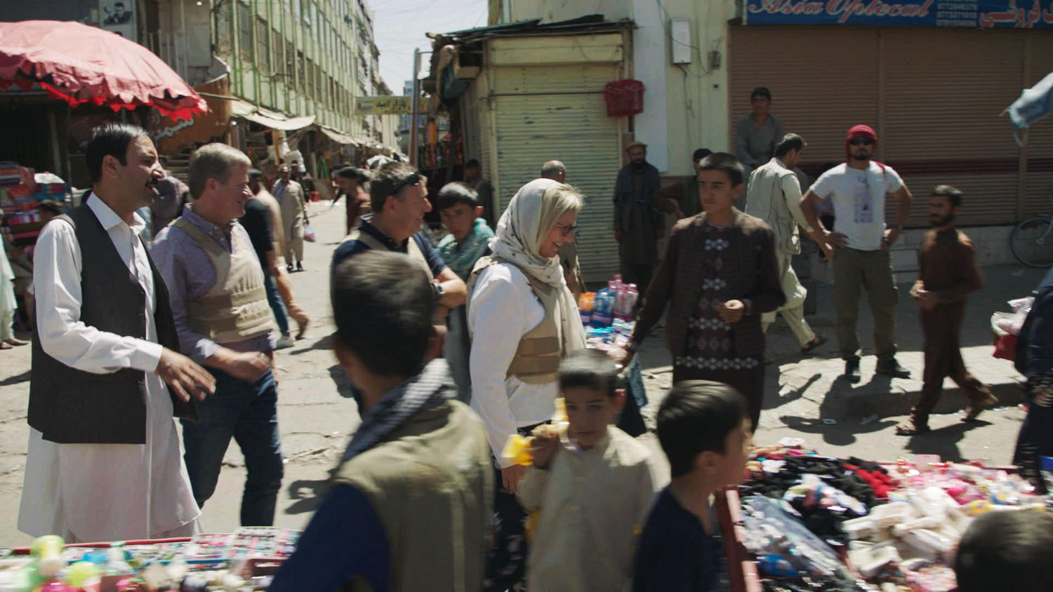 Cathérine Vandoorne, Wouter Torfs en Rudi Vranckx bezoeken markt in Kabul - (c) VRT / Warner Bros Belgium