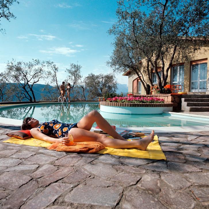 A girl in a flowered swimsuit sunbathing by the swimming pool with a cocktail in the hand. Finale Ligure, 1969 Finale Ligure, Italy. AKG2490294 © akg-images / Mondadori Portfolio / Pino Grossetti A girl in a flowered swimsuit sunbathing by the swimming pool with a cocktail in the hand. Finale Ligure, 1969 Finale Ligure, Italy. AKG2490294 © akg-images / Mondadori Portfolio / Pino Grossetti