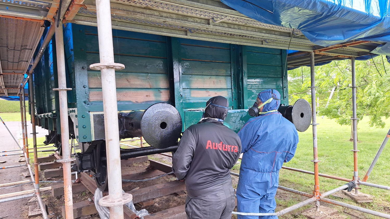 actiefoto restauratie in Richtpunt Zottegem verven van de wagon in originele groen leerling begeleid