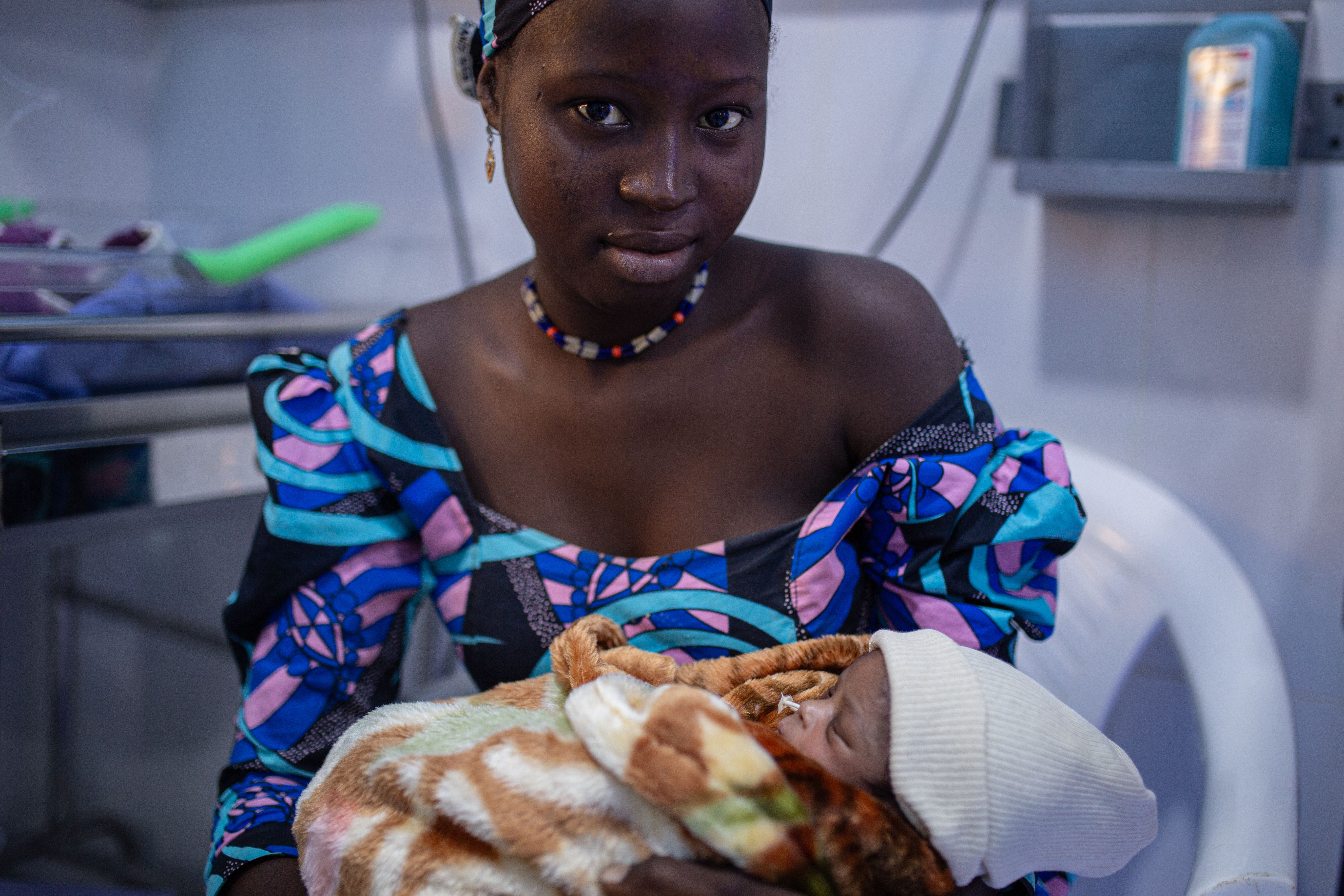 Ramatu had eclampsia, convulsions occurring from high blood pressure, when she delivered her first baby. The baby was born with a head injury and was treated at the MSF Newborn Unit located in the Jahun General Hospital. Ramatu lives five hours away from the hospital, “there is no hospital where I live, and the closest one does not open at night. When I gave birth here, the baby was not crying, but the doctors helped him cry” she explains. The baby lacked oxygen and would have died without medical treatment. Photographer: Alexandre Marcou | 06/12/2023 | Nigeria Ramatu had eclampsia, convulsions occurring from high blood pressure, when she delivered her first baby. The baby was born with a head injury and was treated at the MSF Newborn Unit located in the Jahun General Hospital. Ramatu lives five hours away from the hospital, “there is no hospital where I live, and the closest one does not open at night. When I gave birth here, the baby was not crying, but the doctors helped him cry” she explains. The baby lacked oxygen and would have died without medical treatment. Photographer: Alexandre Marcou | 06/12/2023 | Nigeria