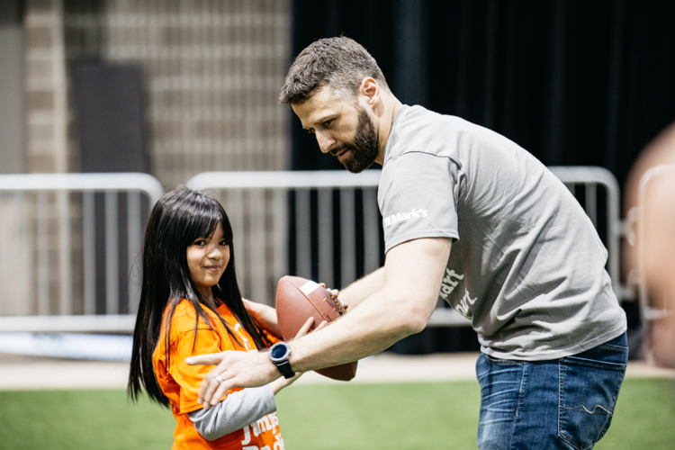 Quarterback Mike Reilly with a participant at the JumpStart Games. Photo credit: CFL.ca/Reid Valmestad