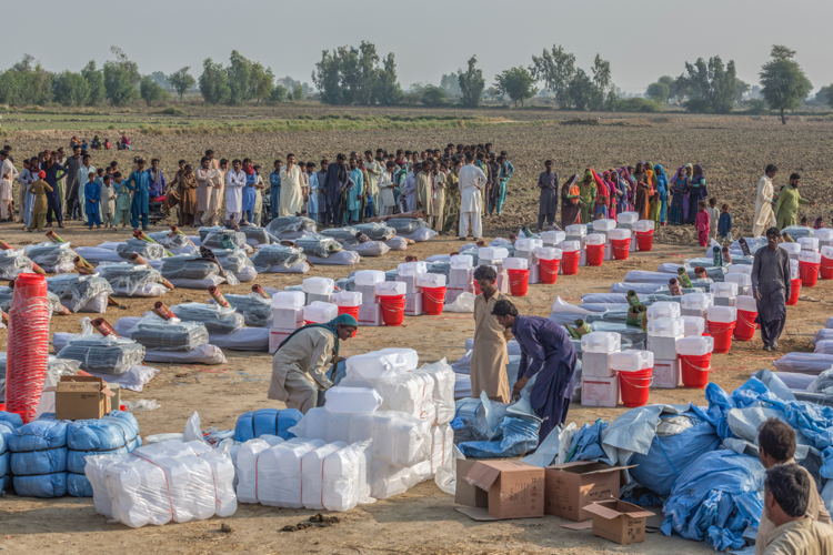MSF staff and volunteers arranges Non Food Items (NFIs) kits for distribution, as peoples affected by flood and rainwater waits to receive NFIs at a village near Sanghar, Sindh province of Pakistan on 16th November 2022. (c) Asim Hafeez for MSF MSF staff and volunteers arranges Non Food Items (NFIs) kits for distribution, as peoples affected by flood and rainwater waits to receive NFIs at a village near Sanghar, Sindh province of Pakistan on 16th November 2022. (c) Asim Hafeez for MSF