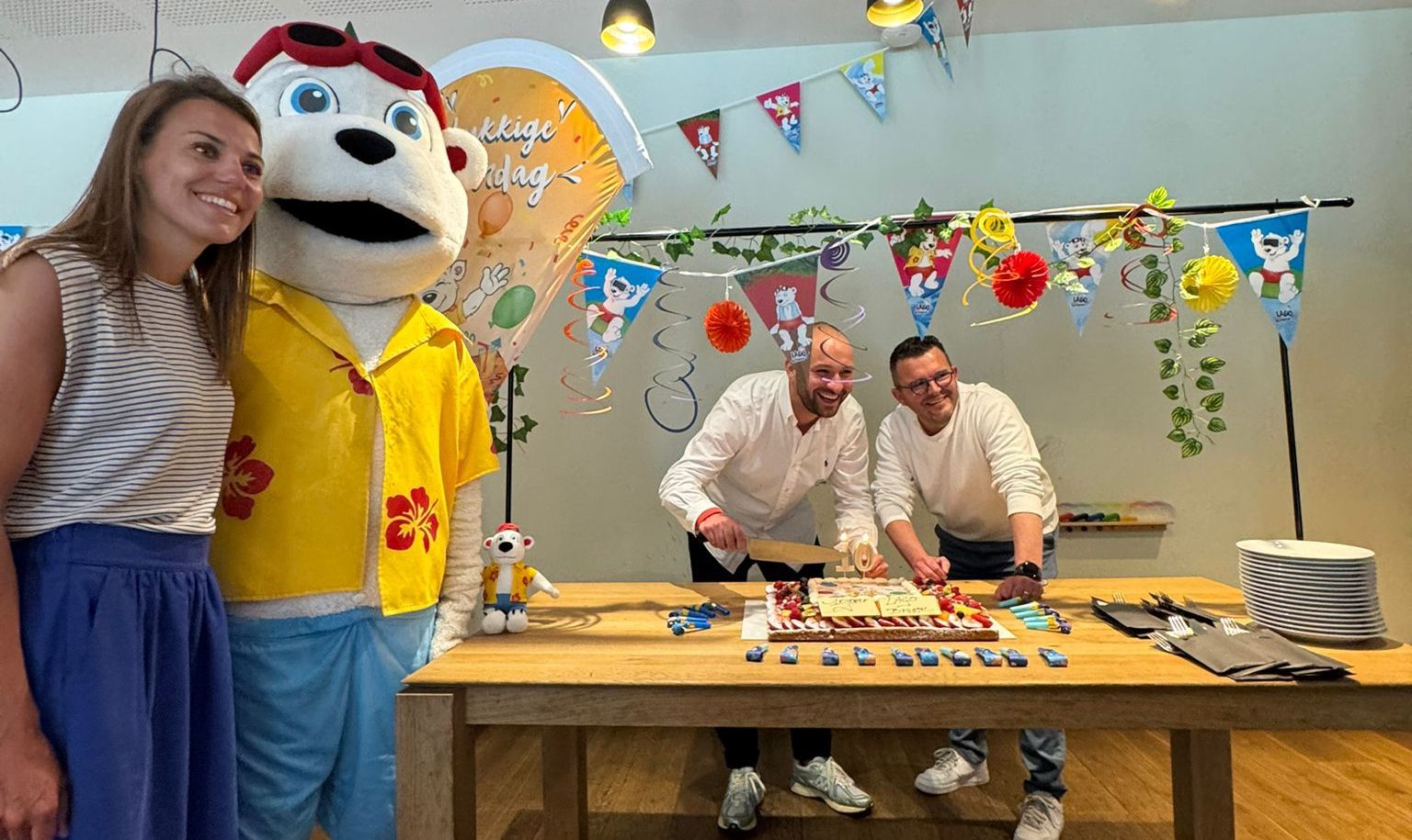 Centrummanager van LAGO Brugge Hans Vanpoucke en Schepen van sport Olivier Strubbe snijden de feesttaart aan.