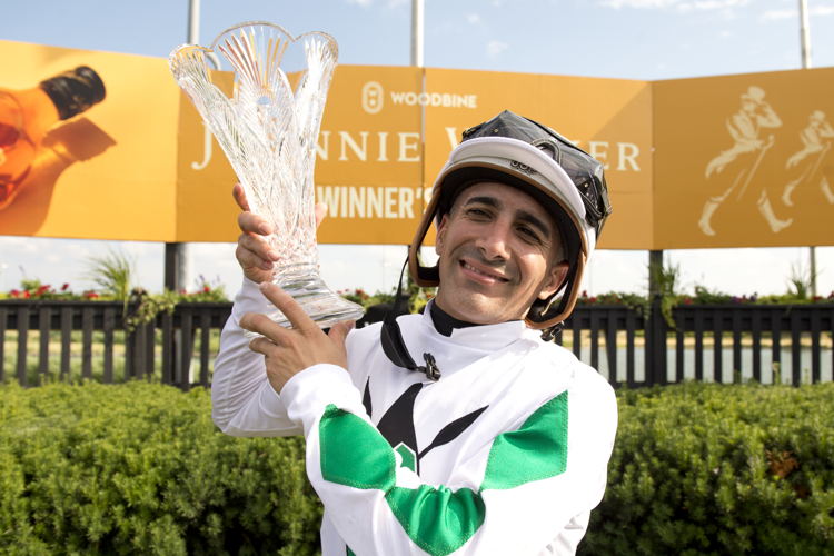 Rafael Hernandez lifts the Woodbine Oaks presented by Budweiser trophy. (Michael Burns Photo)