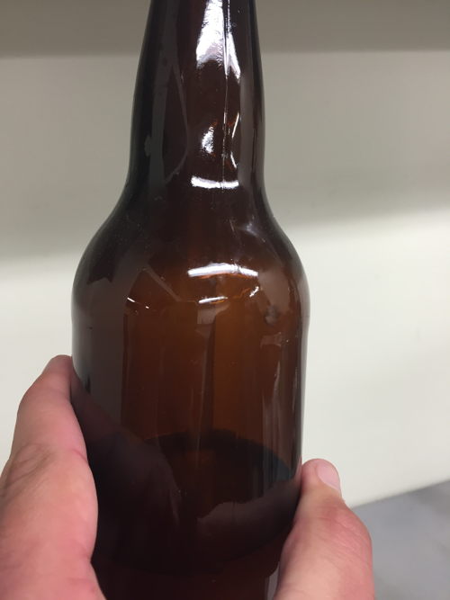 Filling the sanitized bottles with cantaloupe gose