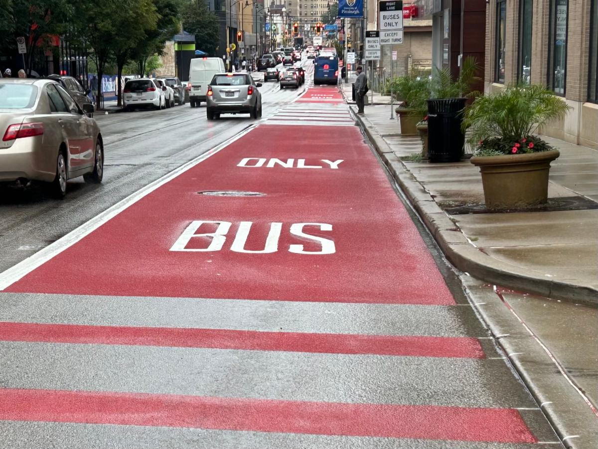 White lettering recently placed on the red bus lane on Forbes Avenue in Oakland