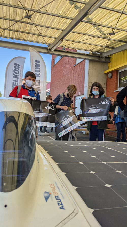 Scholieren verzamelen zich rond de zonnewagen van het Agoria Solar Team