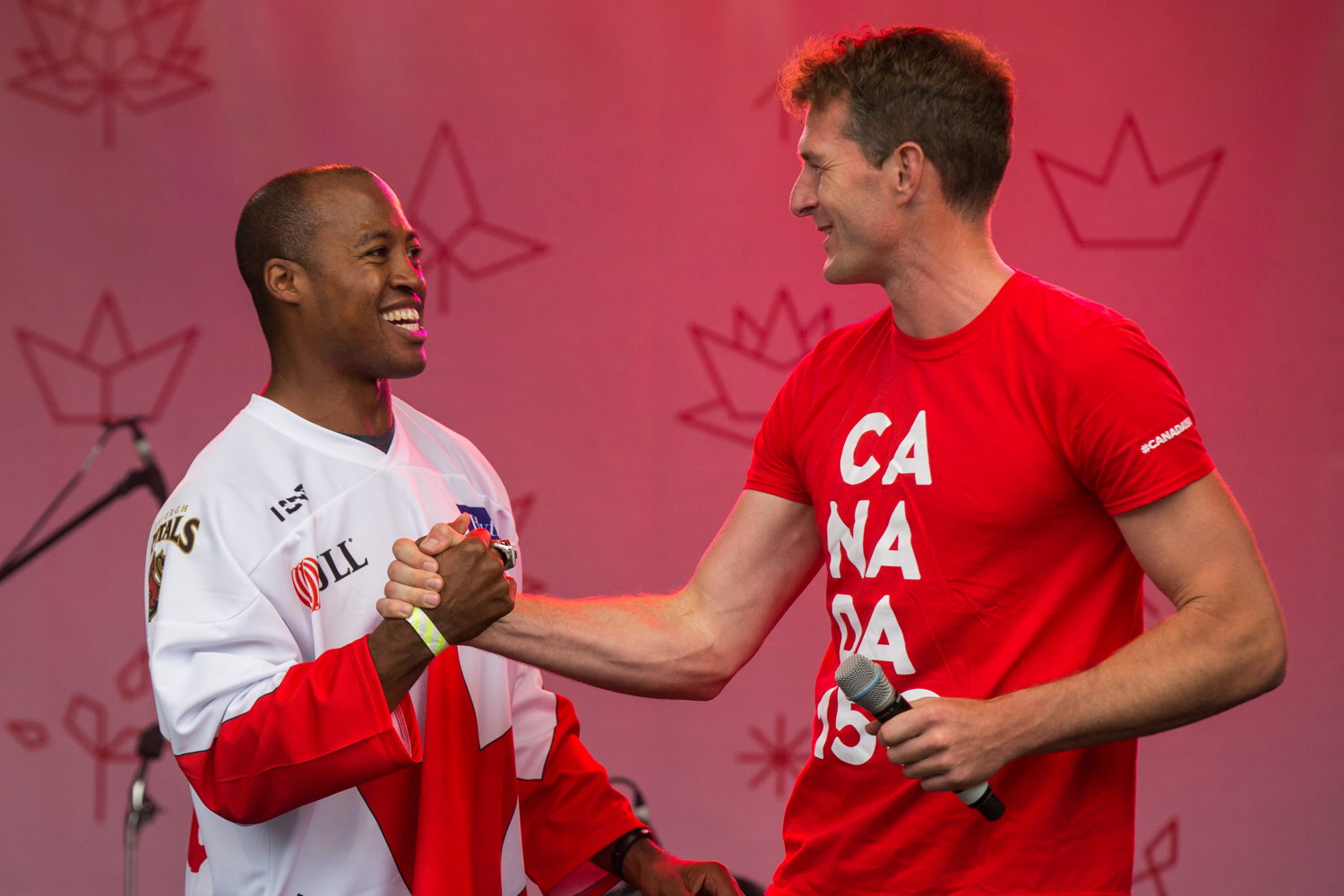 Henry Burris and Dan Snow shake hands on the main stage. Photo Credit: Jim Ross/CFL